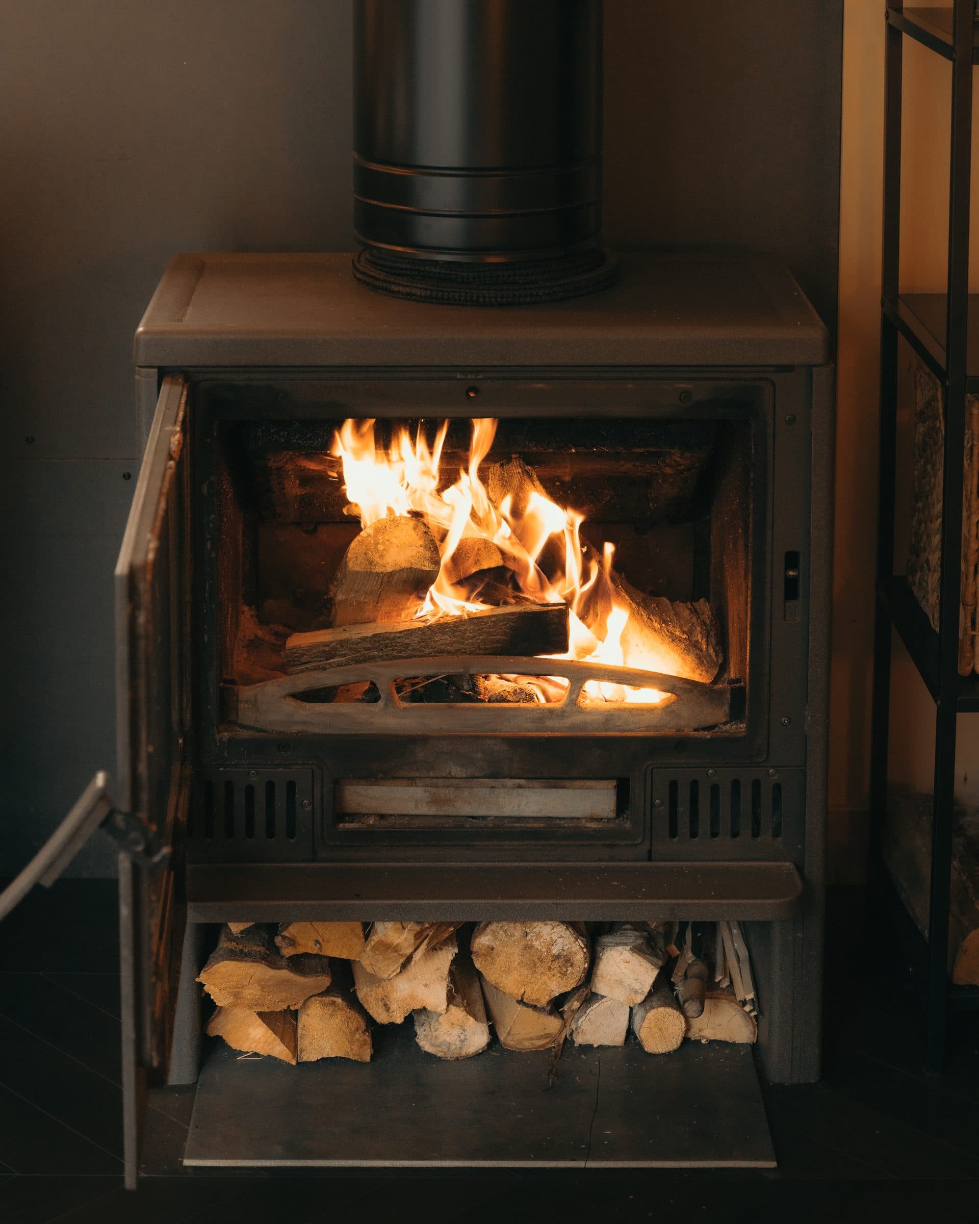 The wood stove, glass front, fire inside