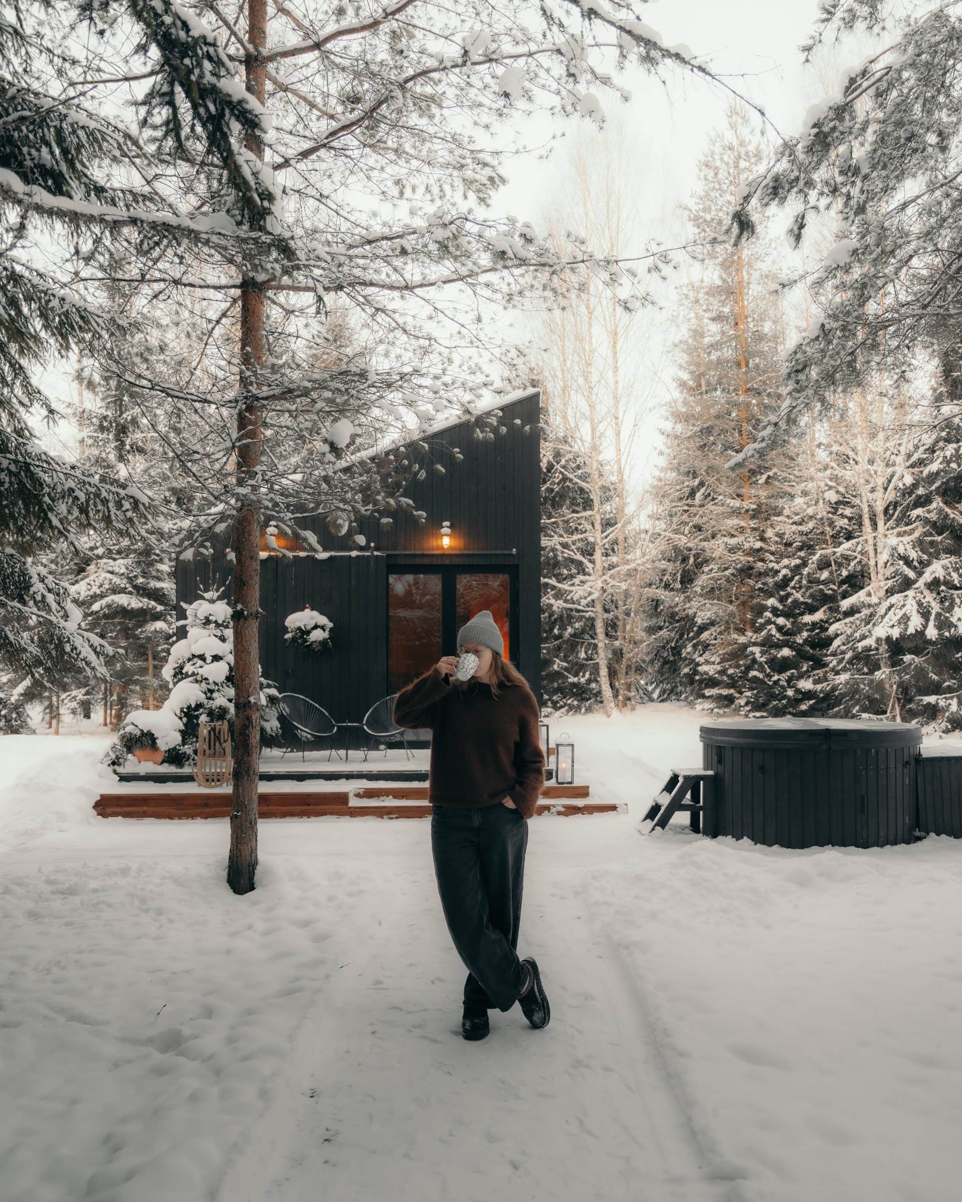 Briežu Stacija — black spruce cabin in winter, hot tub, lanterns, snow forest