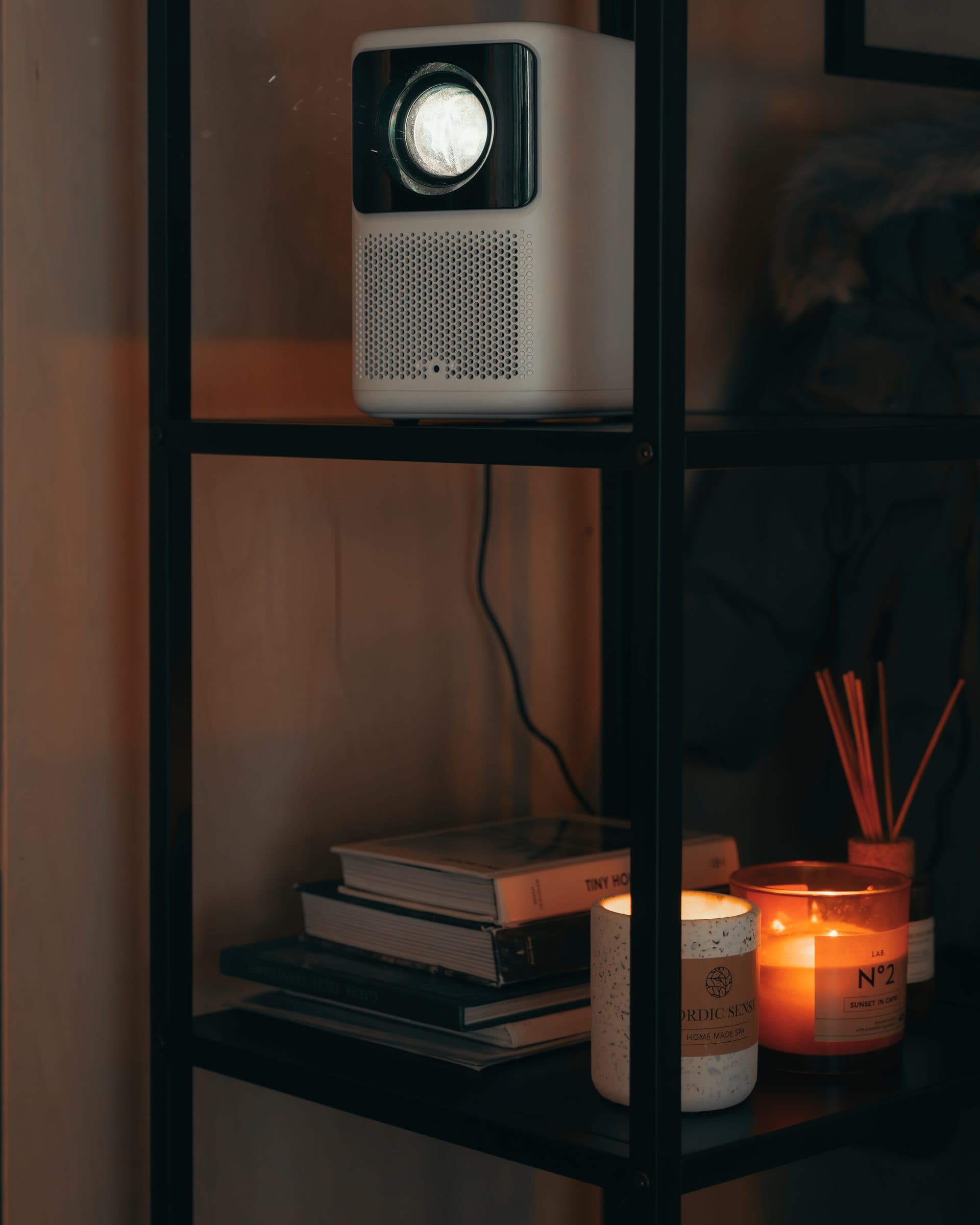 The projector on the shelf, candles below